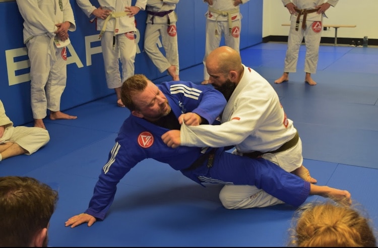 Gracie Barra Anniston instructor spars with student for bjj class while students learn