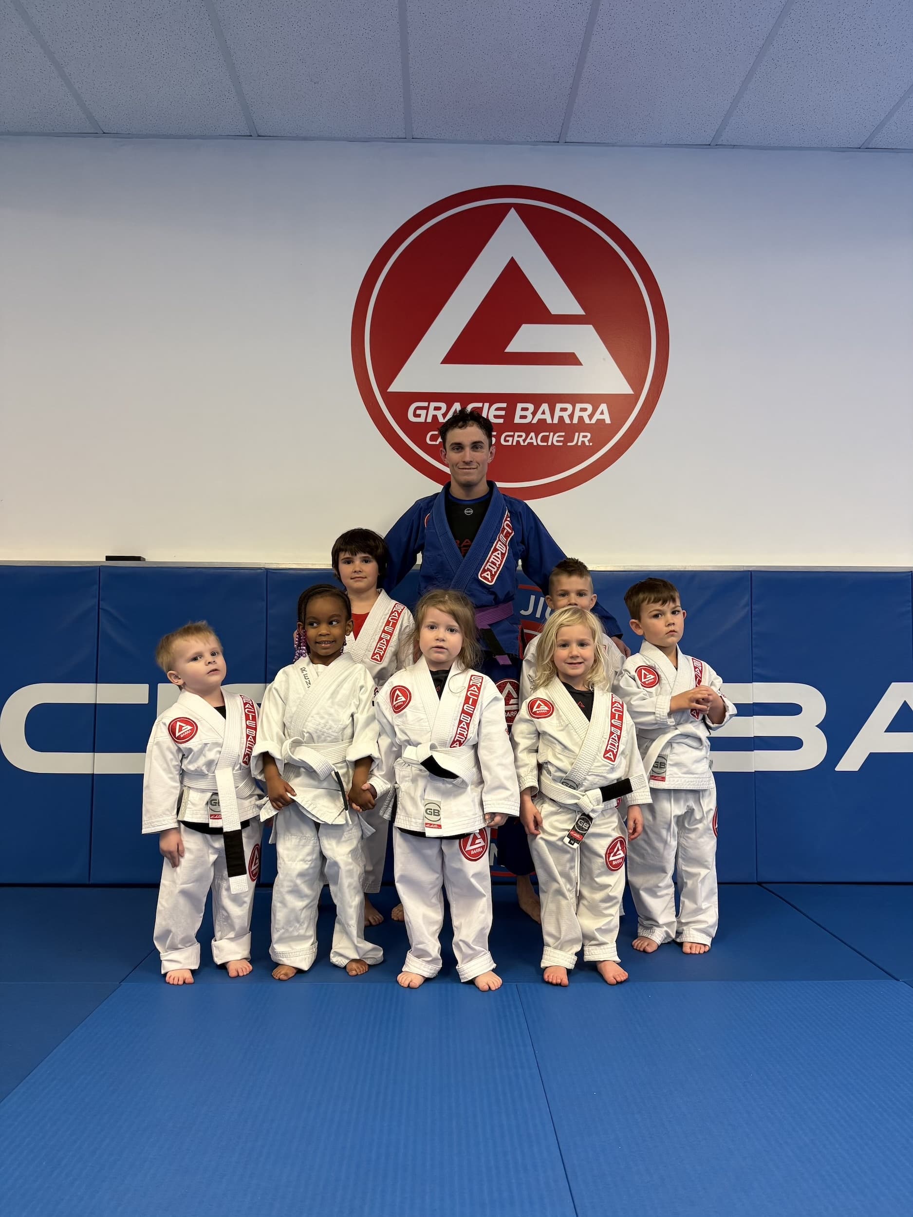 Gracie Barra Anniston instructor posing with young bjj students