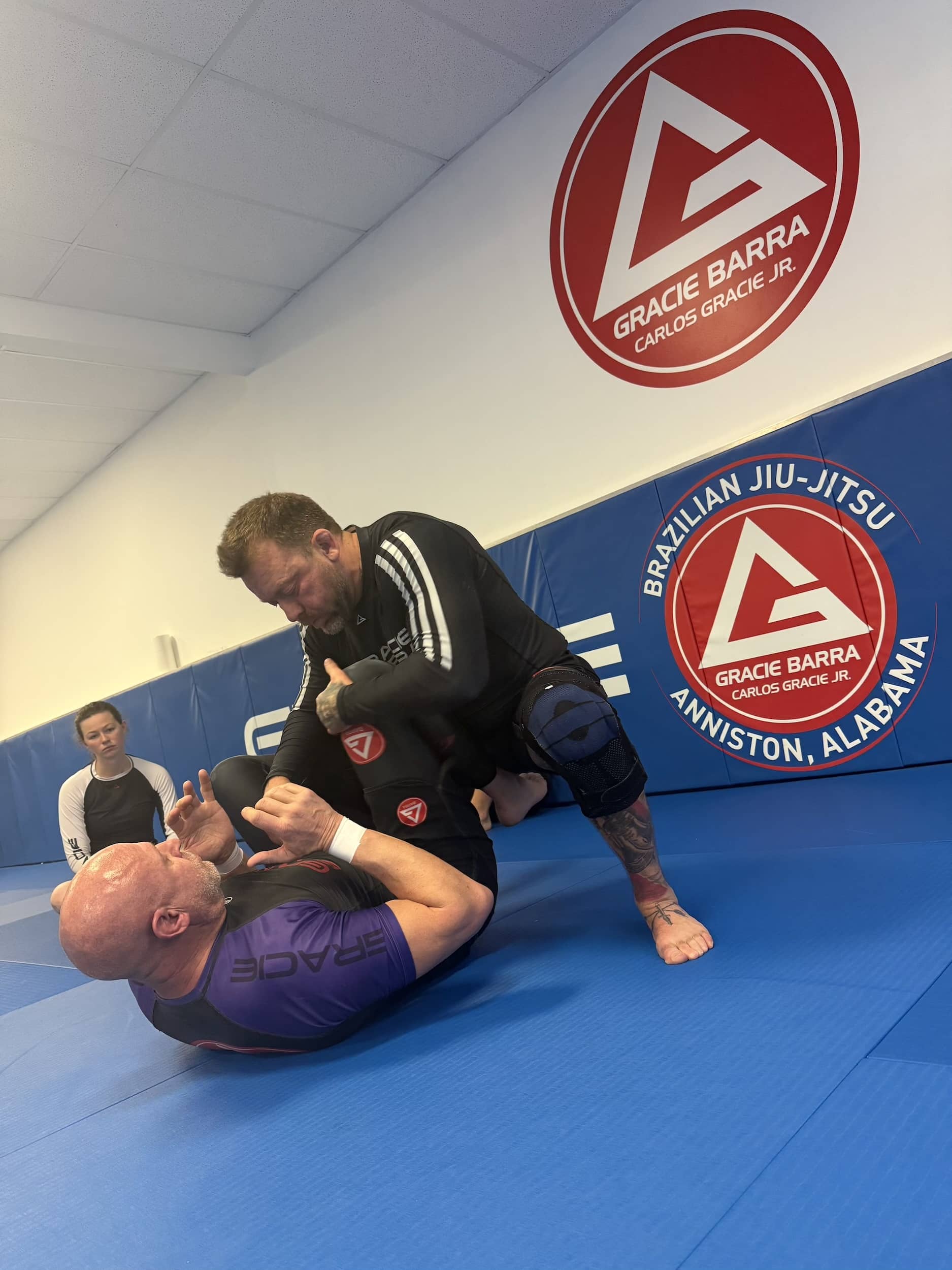 instructor at Gracie Barra Anniston give proper bjj technique demonstration while students learn