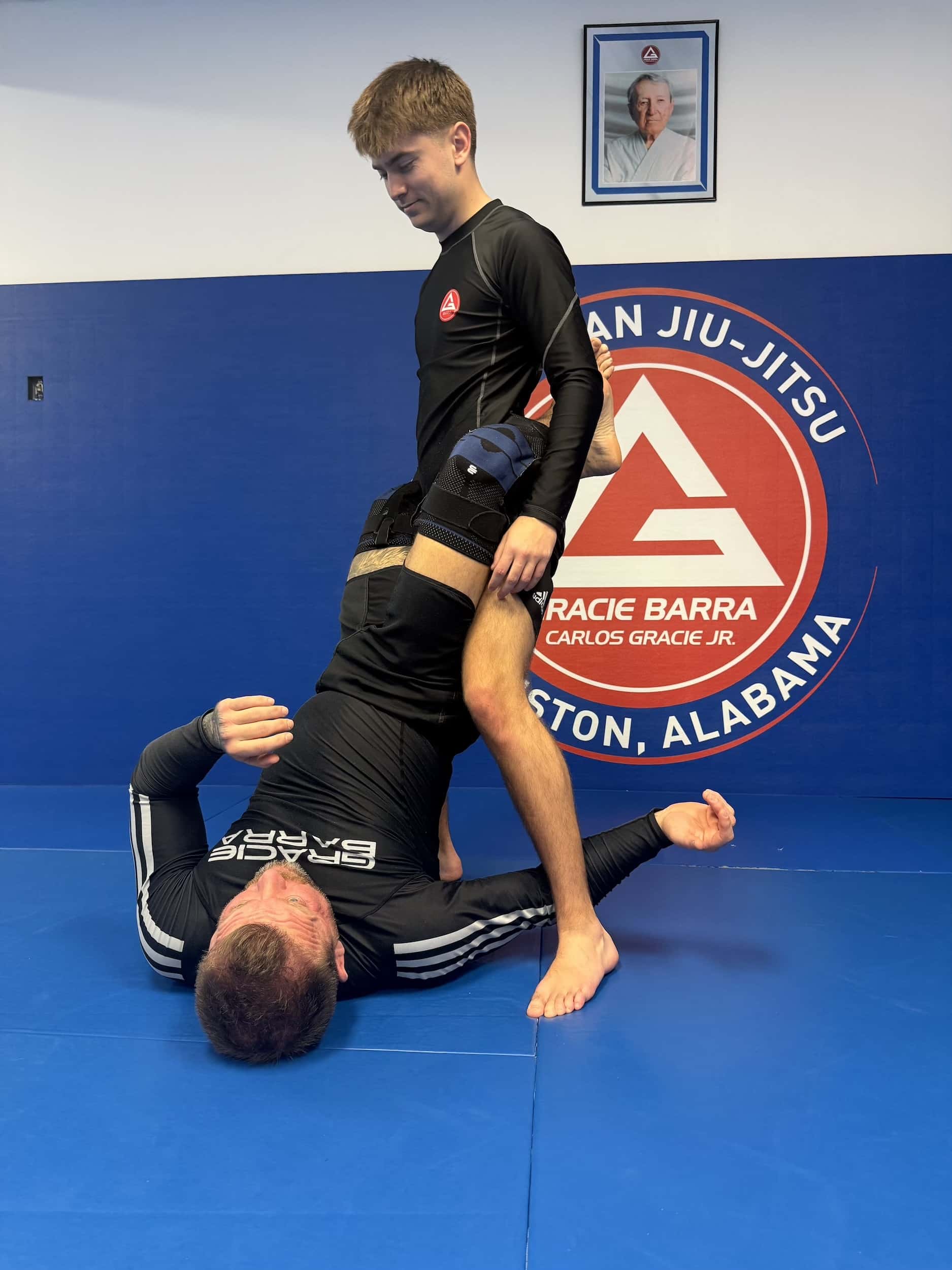 Gracie Barra Anniston instructor helping student with proper bjj techniques